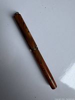 Full view of the closed vintage Waterman fountain pen with marbled orange and brown resin body and gold trim.