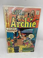 Front cover of Little Archie #112 comic book showing colorful illustration of magic show scene with Little Archie stepping into a magic box and Sabrina watching.