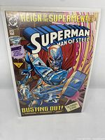Front cover showing Superman Man of Steel armored character bursting out, cover price and bonus Man of Steel poster text visible.