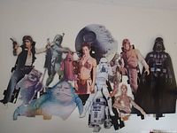 Full view of the cardboard cut-out collage mounted on a wall showing most characters in the set.