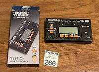 Boss TU-80 tuner and metronome device with original box showing front and model details.