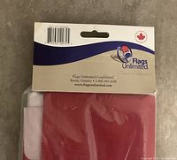 Photo of the flag folded in original clear plastic packaging with a branded paper header showing size 36 x 72 and Flags Unlimited logo