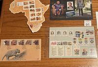 Photo showing a continent-shaped South African stamp sheet, envelope with leopard design, and other special edition stamps