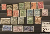 Collection of 22 used Newfoundland postage stamps arranged in rows on a black background, showing varying colors, denominations, and postmarks.