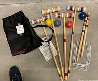 Full view of the croquet set items including mallets, balls, wickets, carrying bag, and instruction sheet.