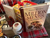Photo showing fermentation jar, condiment jars, kombucha scoby jar, and cookbooks including Million Menus and Plant Paradox Family Cookbook.