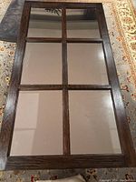 Full view of the window pane style mirror showing the six individual mirrored sections divided by a dark wooden frame.