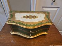 Top and slightly angled front view showing painted decorative top and shape