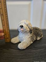 Front-left angled view of the dog sculpture with ruler showing height of about 4.5 inches.