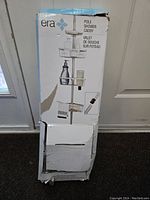 Front-facing photo of the Era Pole Shower Caddy box showing the product image and branding, box is slightly damaged.