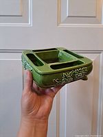 Side view showing the raised vine and leaf pattern and drainage slots on the planter.