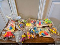 Top view of multiple vintage McDonald's toys in original packaging on a wooden surface