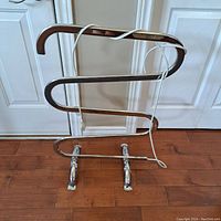 Front view of vintage WarmRails warming rack with tubular chrome frame and power cord wrapped around top bar.