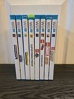 Side view of 8 Wii U game cases showing spine labels with game titles and logos