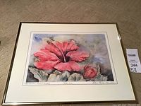 Framed watercolor print showing a red hibiscus flower with gold frame.