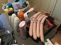 Photo showing caddy with assorted bath and body products including Dove shampoo, Clairol conditioner, and other lotion and soap bottles along with fabric-covered padded hangers and makeup mirror on table.