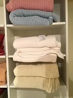 All blankets stacked in shelving unit showing texture and colors