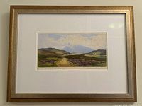 Framed landscape print hanging on wall