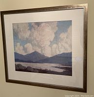 Framed landscape painting with a bronze metal frame hanging on the wall.