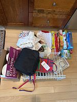 Overview of all kitchen items showing towels, apron, lunch pail, bins, and wire shelves