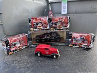 Full view of all diecast items and piggy bank, showing boxed motorcycles and Batmobile, and vintage piggy bank car.