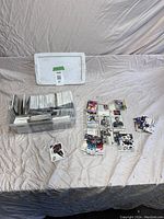 Overview of hockey card lot including cards in plastic bin and several groups of loose cards spread out on surface.