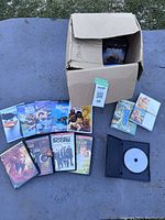 Photo showing assorted DVDs spread out including animated titles and Jackass DVD.