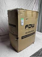 Unopened cardboard box with model and brand details, showing some damage to the box.