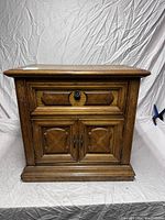 Front view of the solid hardwood nightstand showing drawer and cabinet doors.
