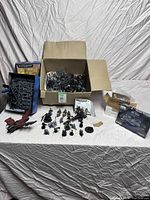 Overview of entire lot on white sheet background showing boxed kits on right, open box of sprues center, assembled miniatures front left