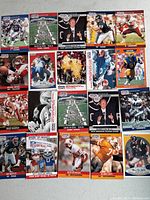 Top view of 25 NFL Pro Set football cards showing various players and commemorative cards related to NFL events and teams.