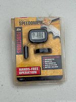 Digital bike speedometer in original packaging with visible LCD display and accessories.