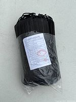 Pack of black disposable face masks with certification label visible showing product specs and manufacturing date.