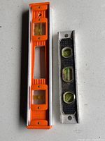 Two levels together showing difference in size and color, one orange with metal frame, one black metal