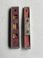 Top view of two metal spirit levels showing bubble vials and red accents.