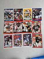 13 NFL Pro Set and Fleer football cards laid out on a gray surface, showing various players.