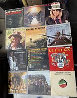 Top view of nine vintage vinyl record albums laid out on floor, showing cover art and titles.