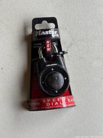 Front view of new Master Lock speed dial combination padlock in retail packaging showing the dial and shackle.