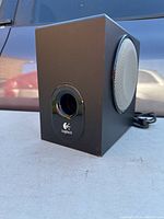 Side view of Logitech subwoofer showing the bass port and Logitech logo on black casing