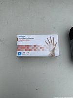 Photo of the full box of McKesson vinyl exam gloves, powder-free, showing packaging and size labeling.