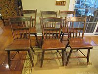 View of six antique wooden chairs arranged in two rows, showing overall condition and matching design.