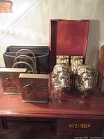 Group photo showing all items including PM Craftsman Lady Justice brass bookends, lion head brass bookends, gold foil Corinthian bookends with corbels, and Eldon wood tray with organizers on a wooden table.