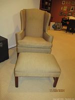 Front view of wingback chair and ottoman showing overall design and scale