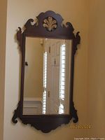 Full view of the rectangular framed mahogany Chippendale mirror with detailed carving and mirror glass reflecting room details.