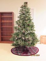 Full assembled 7' artificial Christmas tree with lights and tree skirt