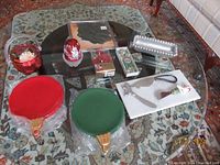 Overview photo showing entire lot on glass table: red and green ceramic serving trays, red glass bowl, fairy lamp, silver-tone tray, marble cheese board with spreaders
