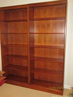 Front view of two matching bookcases side by side showing five shelves each