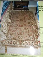 Full view of the hand made Oriental rug on the floor, showing overall pattern and size.