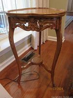 Parlor table showing side and leg details near window with hardwood floor.