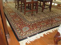 Full view of rug under dining table showing border design and fringe